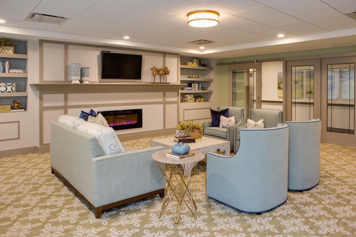 A modern living room featuring comfortable seating, a fireplace, and a television.