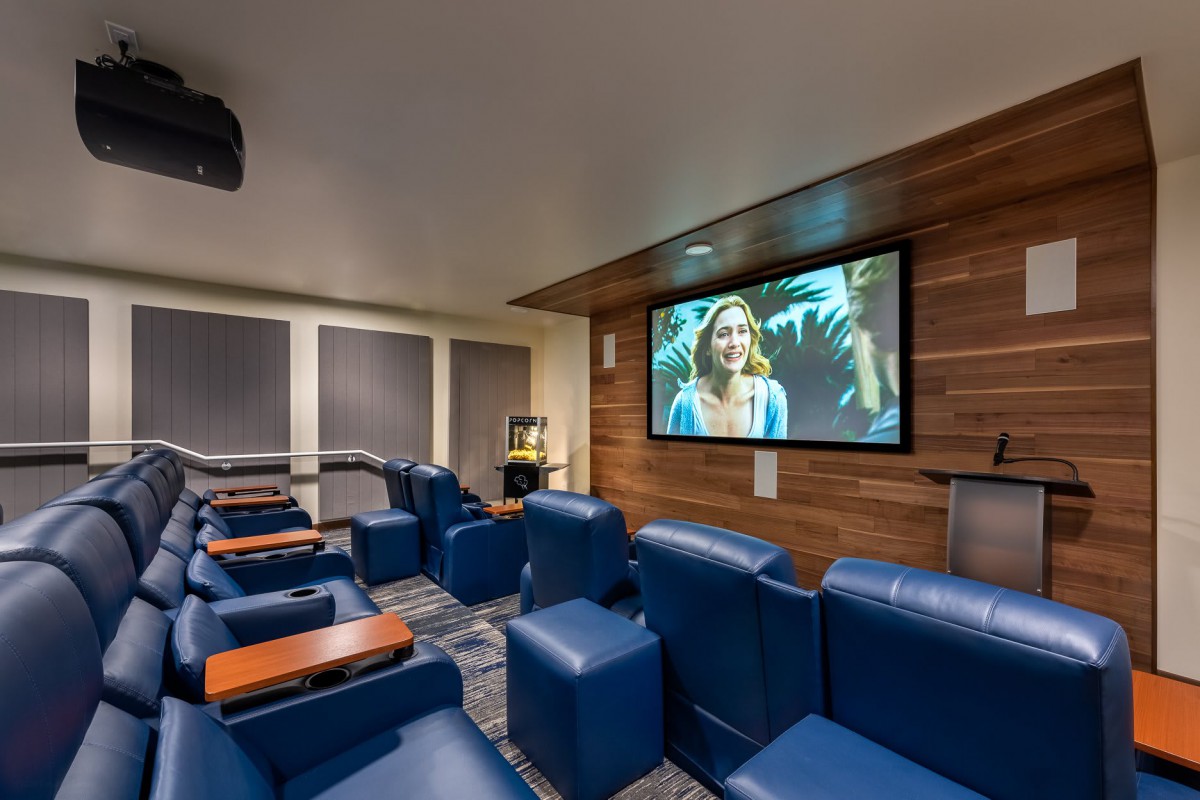 A cozy home theater with comfortable leather seating and a large screen, perfect for enjoying movies at home.