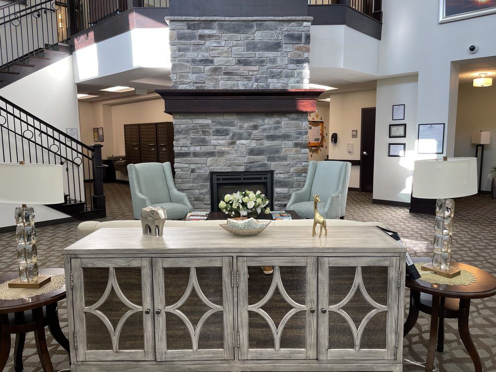 A modern lobby with a central fireplace, comfortable seating, and stylish furniture.