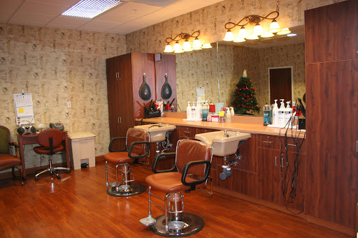 A cozy hair salon featuring stylish chairs and a well-lit mirror area.