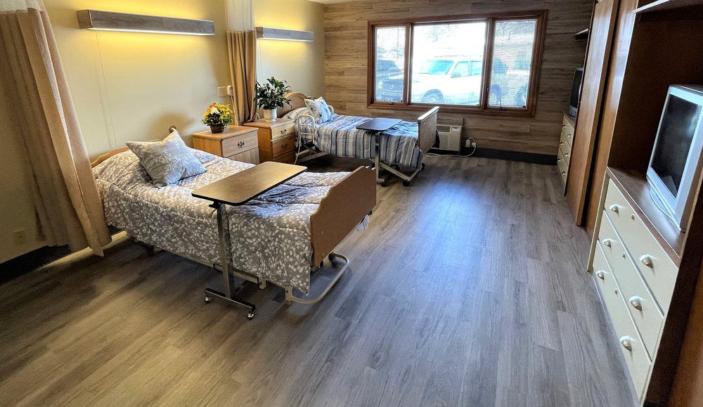 A hospital room with two beds and side tables, designed for patient care.