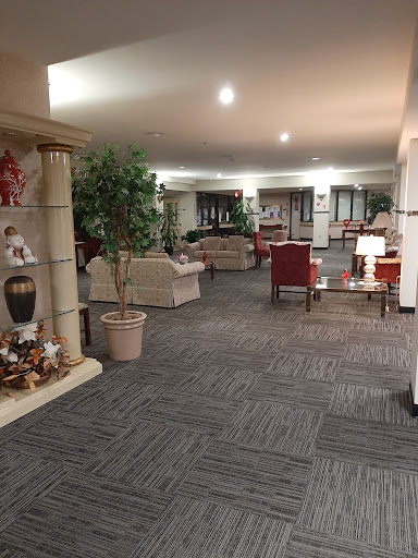 A spacious and inviting lobby area featuring cozy seating, decorative plants, and warm lighting.