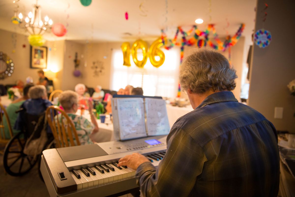 A lively birthday celebration with music being played on a piano, highlighting a milestone age of 106.