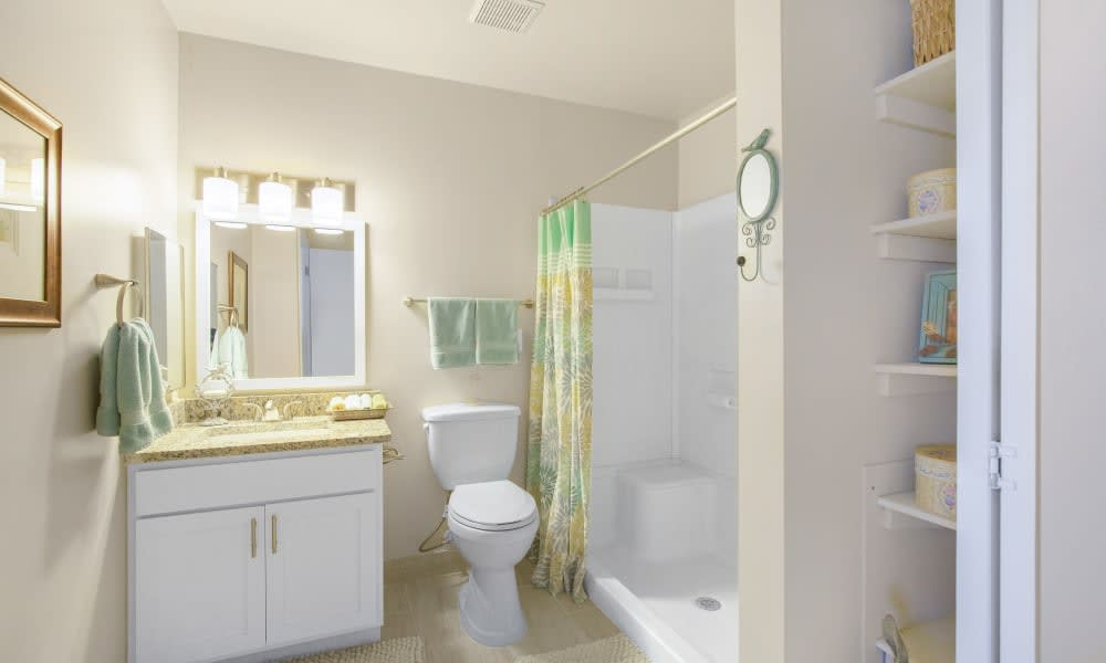 A clean and bright bathroom with a shower, toilet, and sink.