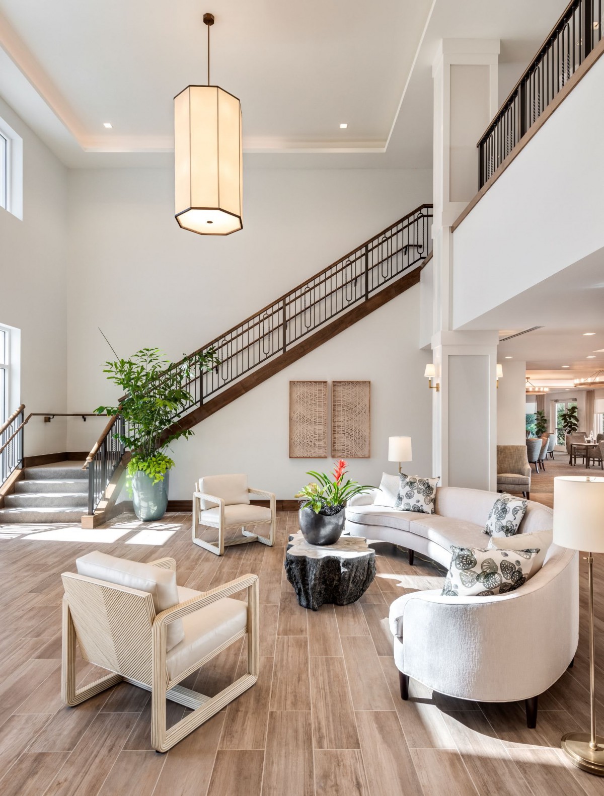 A modern lobby with stylish furniture and a grand staircase.