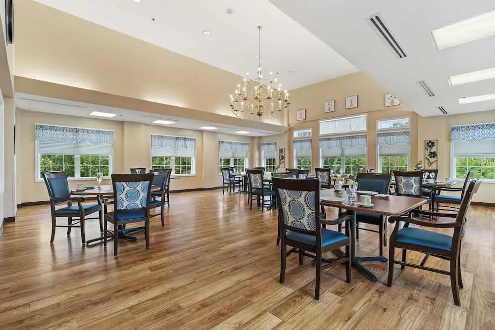 A spacious dining area with elegant furniture and a chandelier.