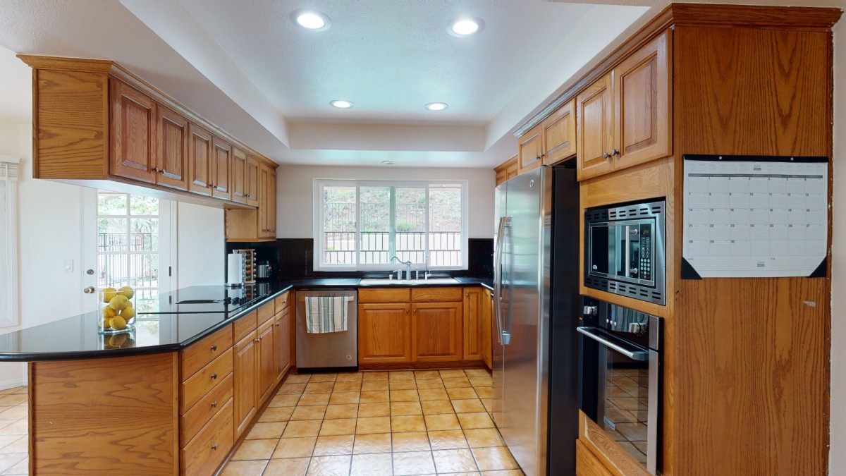 A modern kitchen with wooden cabinets and stainless steel appliances.