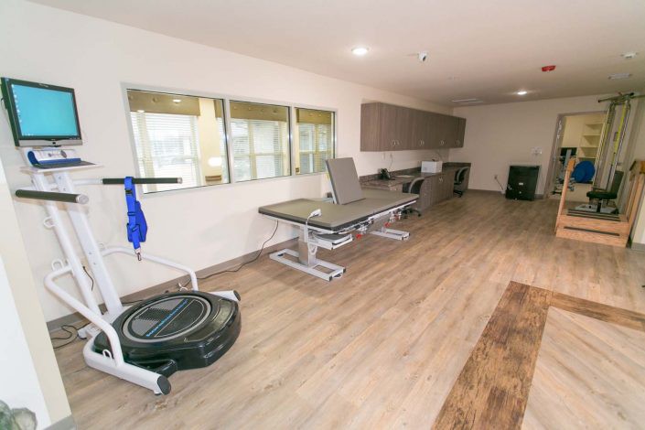 A rehabilitation room equipped with therapy tables and exercise equipment.