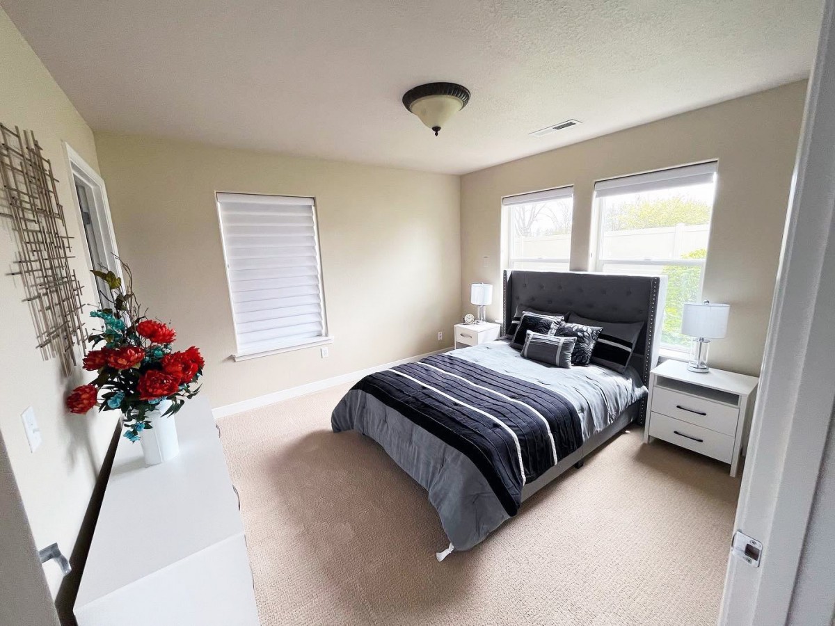 A modern, minimalist bedroom with a double bed and stylish decor.