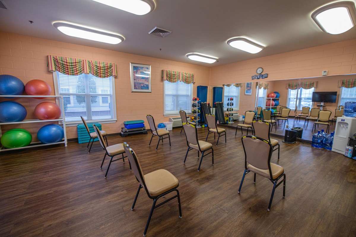 An empty room with chairs arranged in a circle, likely set up for a group activity or class.
