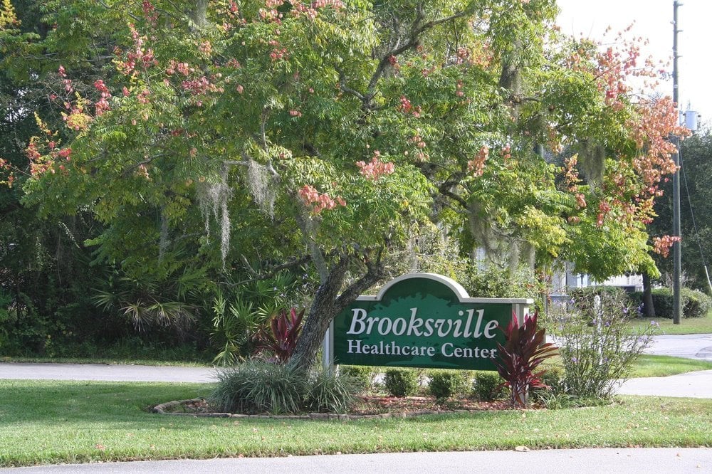 Sign for Brooksville Healthcare Center surrounded by trees.