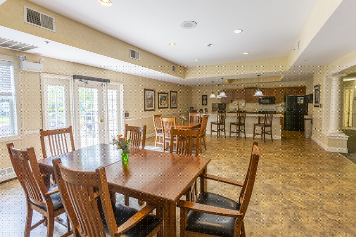 An open-layout dining area with wooden furniture and a view into the kitchen.