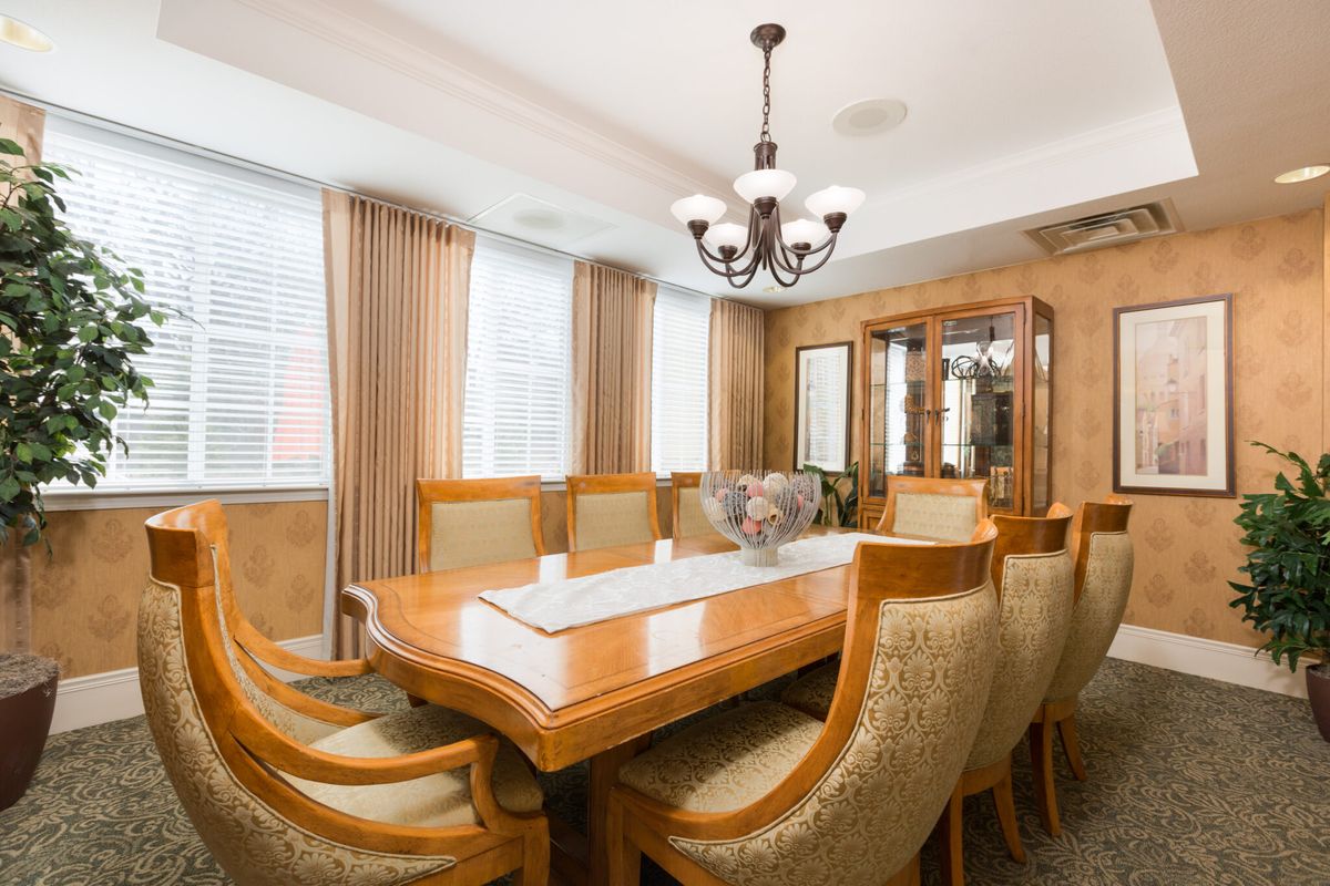 A beautifully designed dining room with an elegant wooden table, upholstered chairs, and a chandelier.
