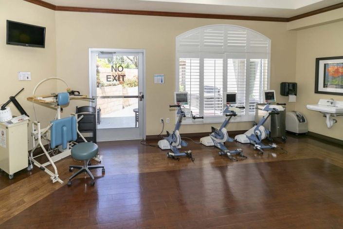 A dental office with multiple dentist chairs and equipment arranged in a clean, bright room.