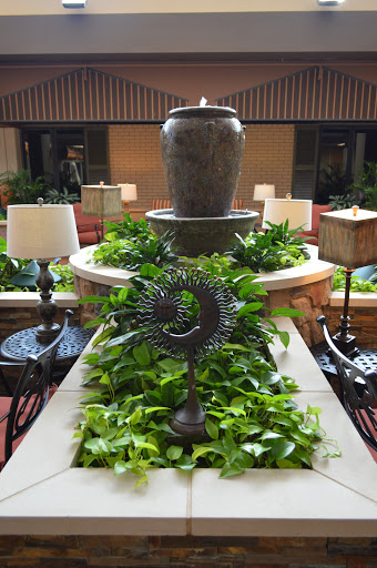 A serene indoor fountain surrounded by lush greenery and elegant lighting.