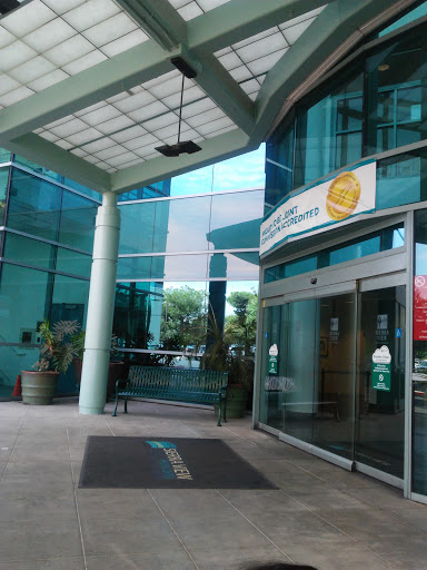 The entrance of a modern glass building with clear signage.