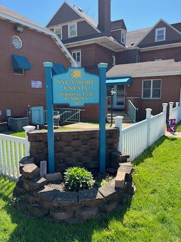 A welcoming sign indicating a local community center, surrounded by well-maintained landscaping.