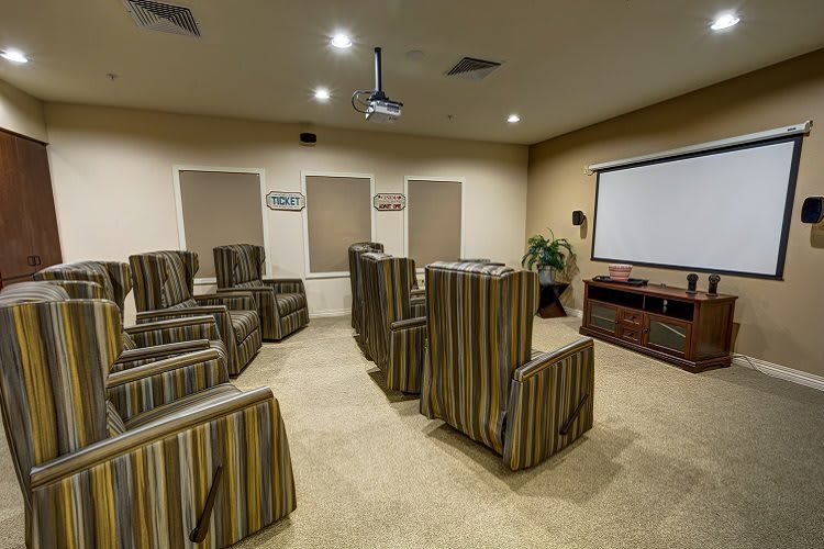 A cozy home theater with striped seating and a projector screen for entertainment.
