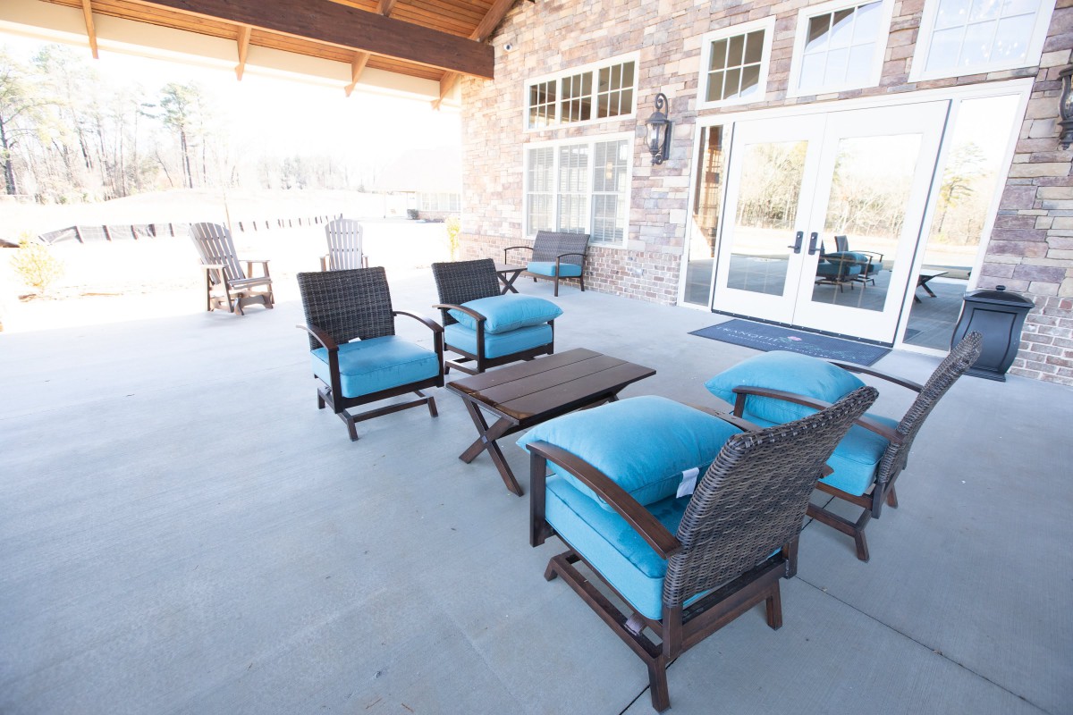 Outdoor patio setup with blue-cushioned wicker furniture.