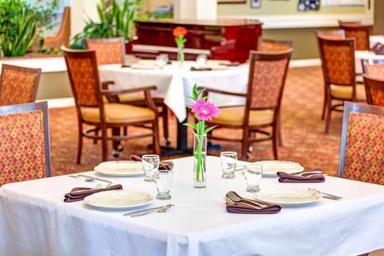 A beautifully set restaurant table with a floral centerpiece and elegant place settings.