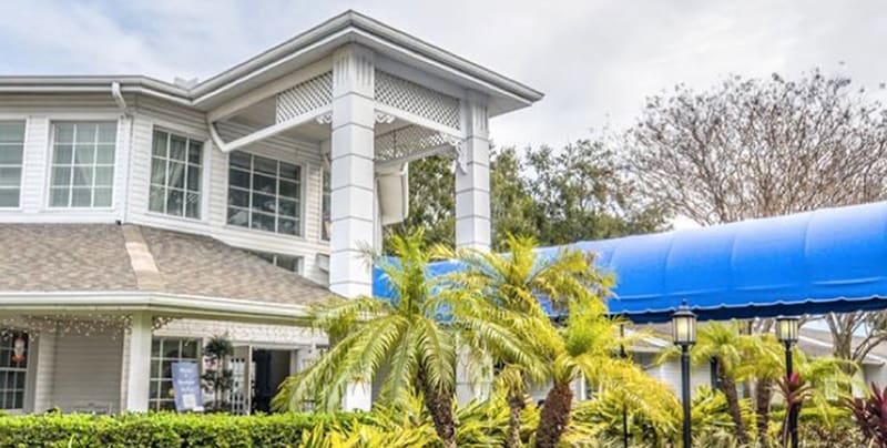 A tropical-themed building with palm trees and a blue awning.