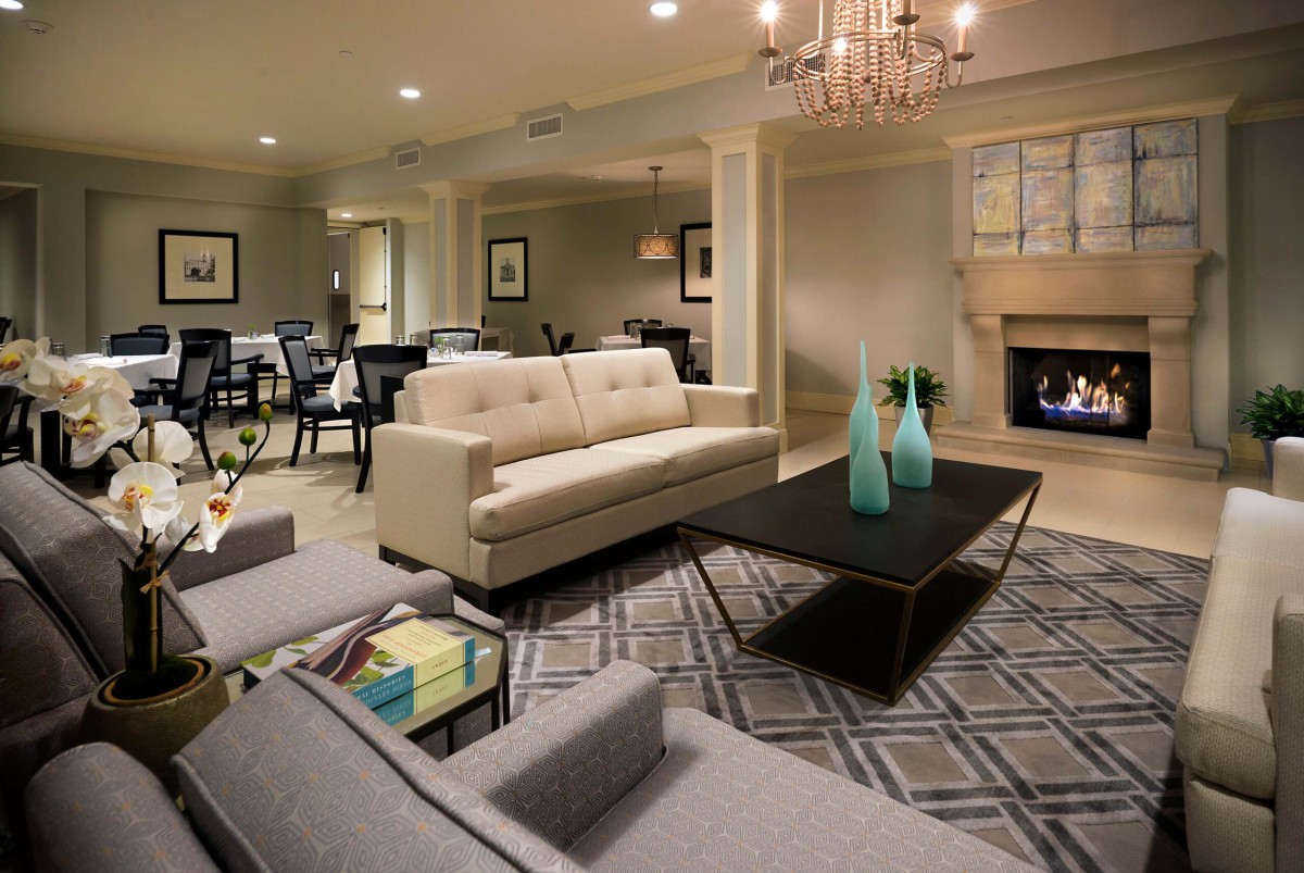 A modern living room with chic furniture and a cozy fireplace.