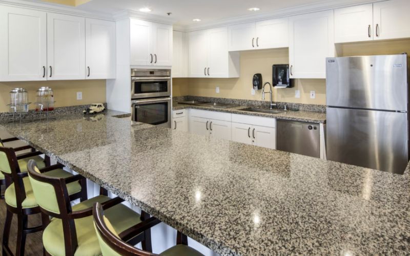 A modern kitchen with granite countertops and stainless steel appliances.