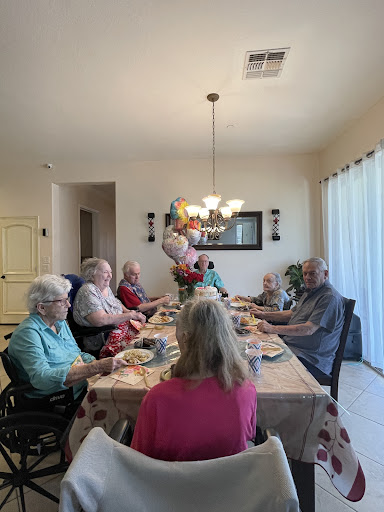 A joyful family gathering around the dinner table, sharing delicious food and good company.