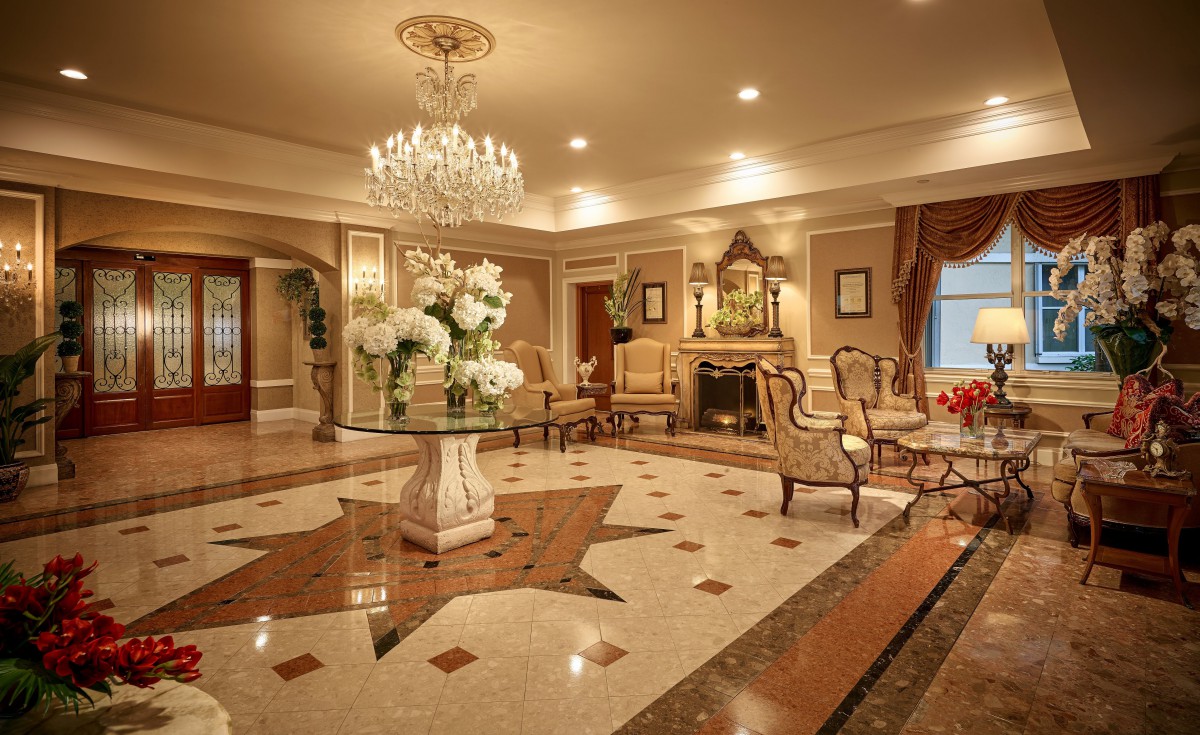 A luxurious and elegant hotel lobby with a grand chandelier, exquisite marble flooring, and comfortable seating arrangements.