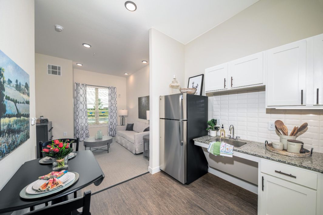 A modern apartment interior featuring a compact kitchen and an open living space.