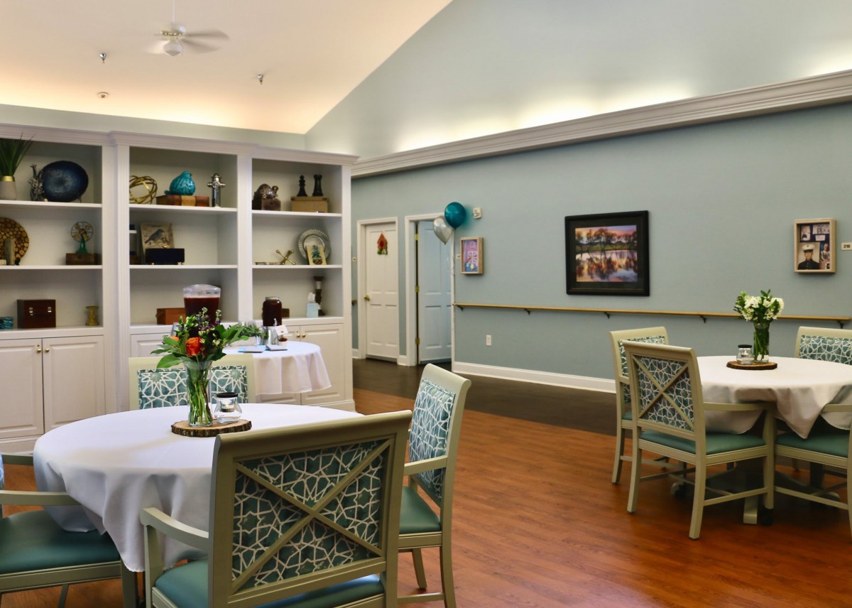 A cozy dining room with decorated tables and artwork on the walls.