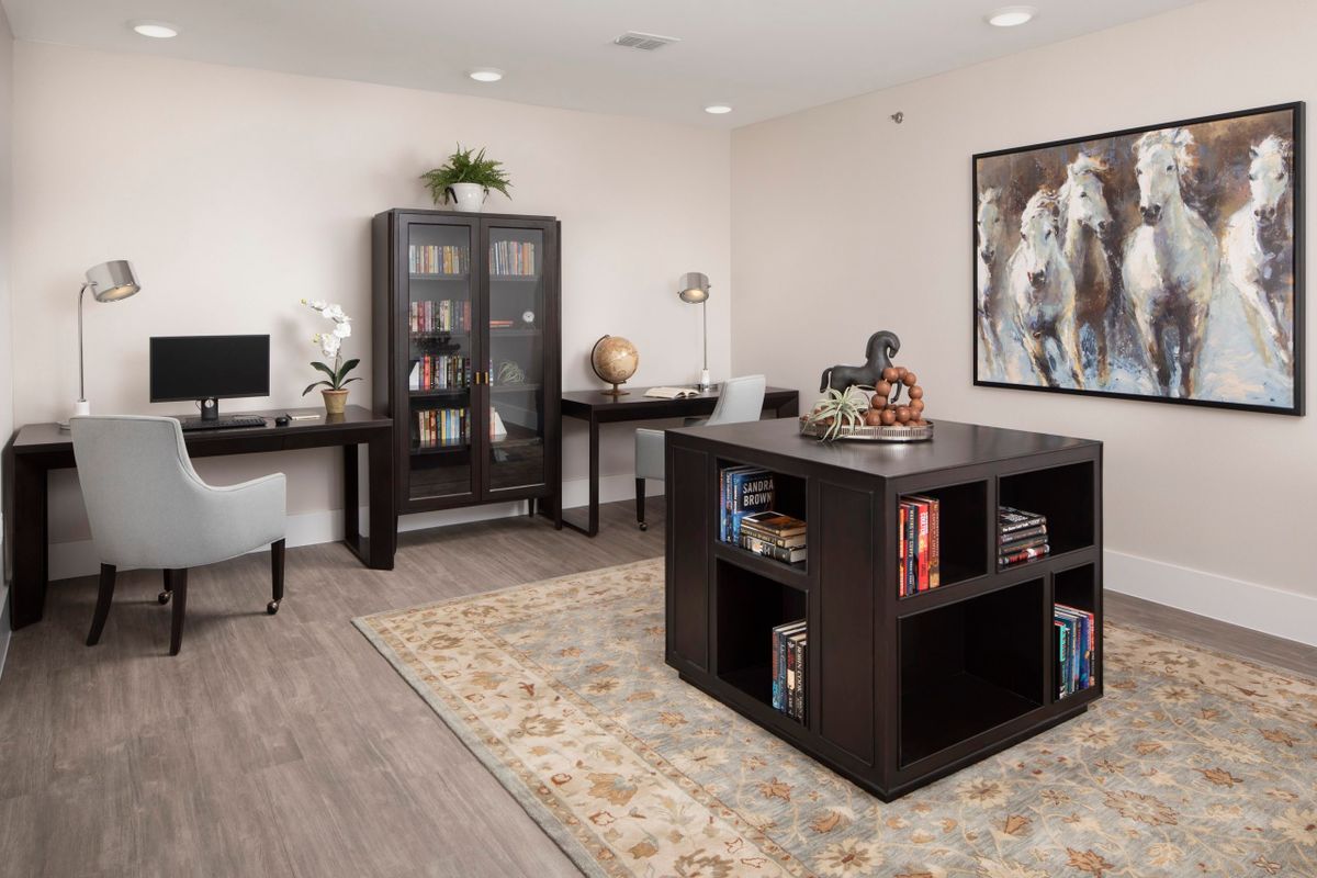 A modern home office with a computer desk, bookshelf, and decorative elements.
