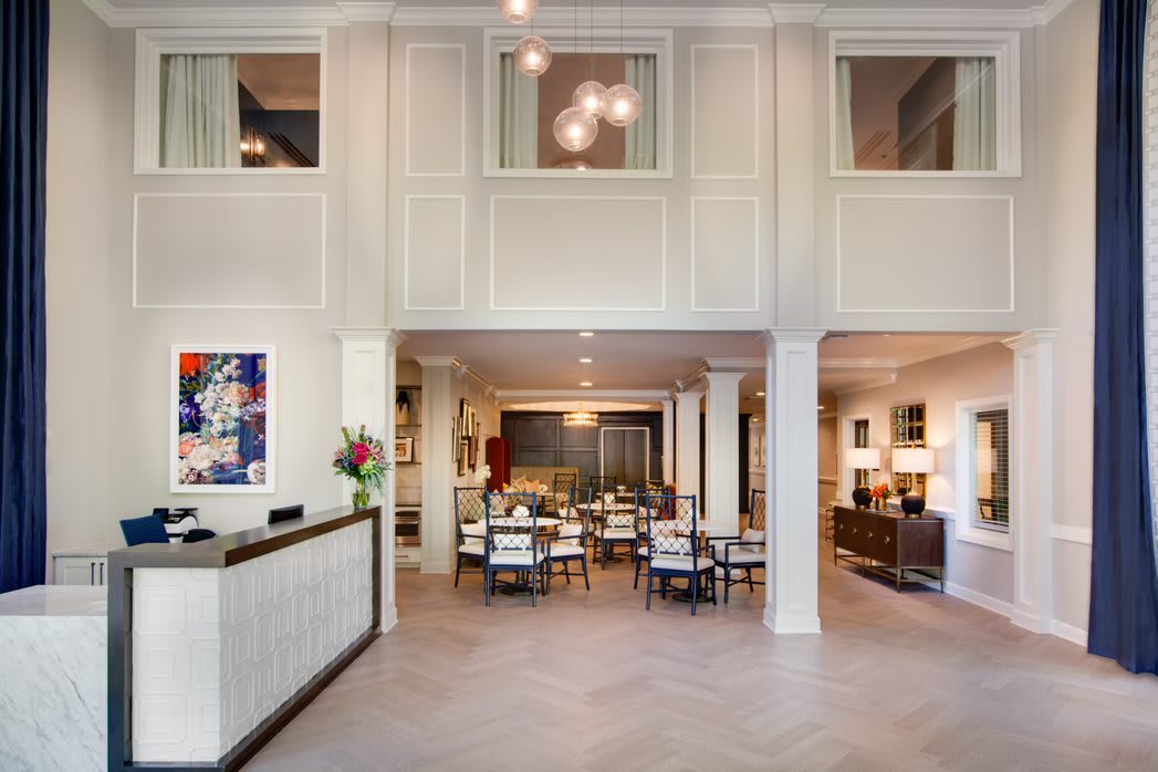 A modern lobby area with reception desk, seating, and artistic decor.