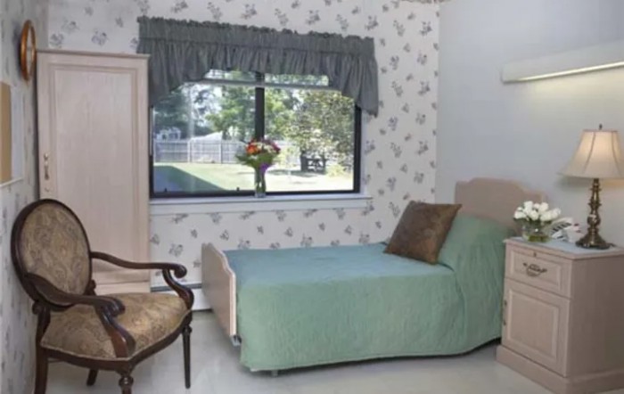 A cozy bedroom with a single bed, decorated with floral patterns and a window view.