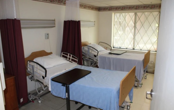 A clean and organized hospital room with two empty beds ready for patients.