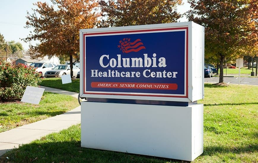 Sign for Columbia Healthcare Center with autumn trees in the background.