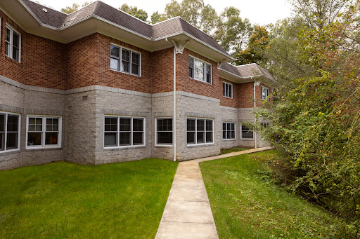A modern residential building with a well-maintained lawn and pathway.