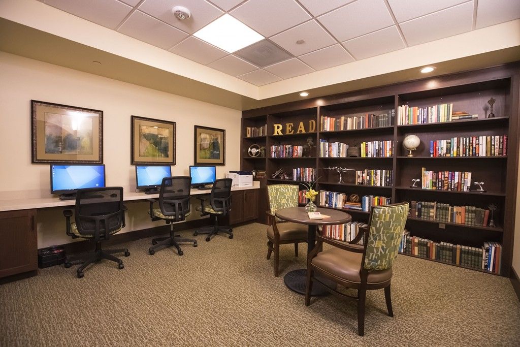 A cozy study area with computers and bookshelves, inviting for reading and digital work.