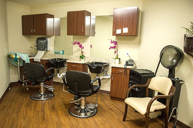 A well-organized hair salon with styling chairs, mirrors, and floral decorations.
