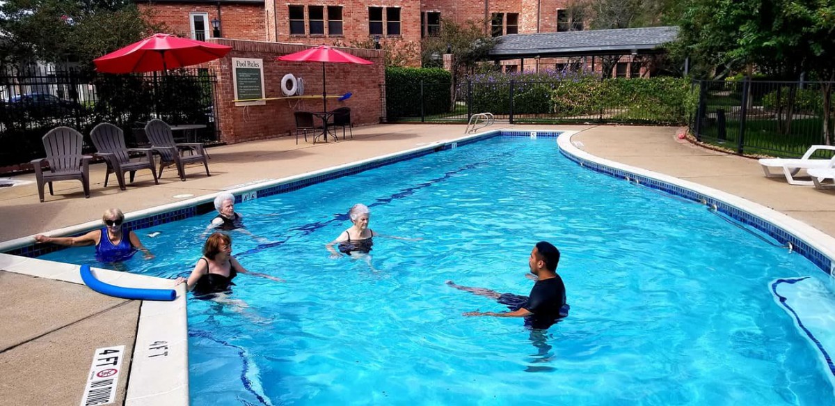 A group of people enjoying activities in a swimming pool.