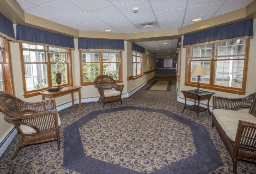 A well-decorated hallway with chairs and large windows providing natural light.