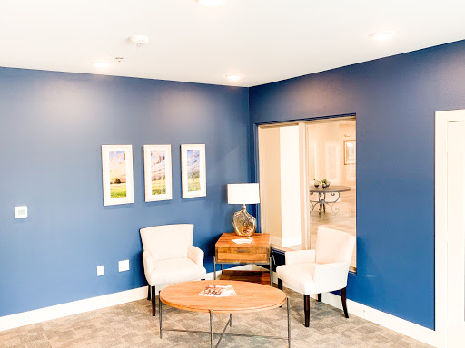 A cozy living room with a modern design featuring a blue accent wall and stylish furniture.