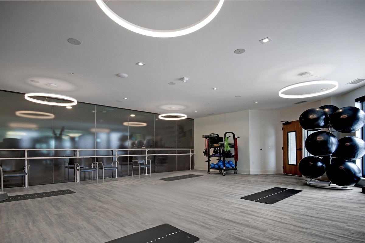 A modern conference room featuring circular lighting fixtures and a glass partition.