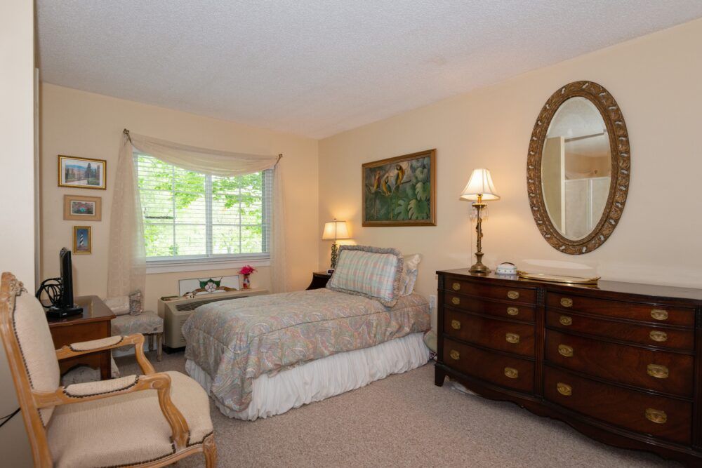 A cozy bedroom featuring a single bed, wooden furniture, and elegant decor.