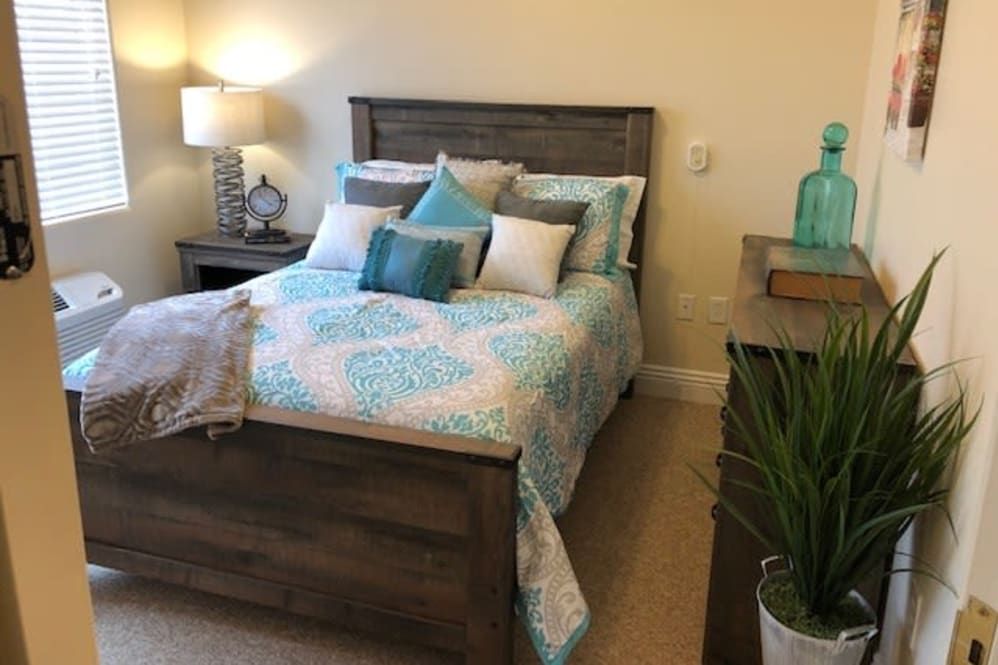 A cozy bedroom with a neatly made bed and stylish decor.