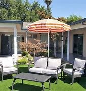 A relaxing patio area with comfortable seating and a striped umbrella.