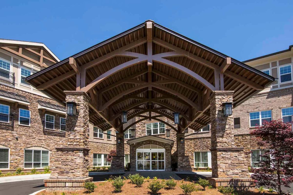 A building with a stone facade featuring a large covered entrance.
