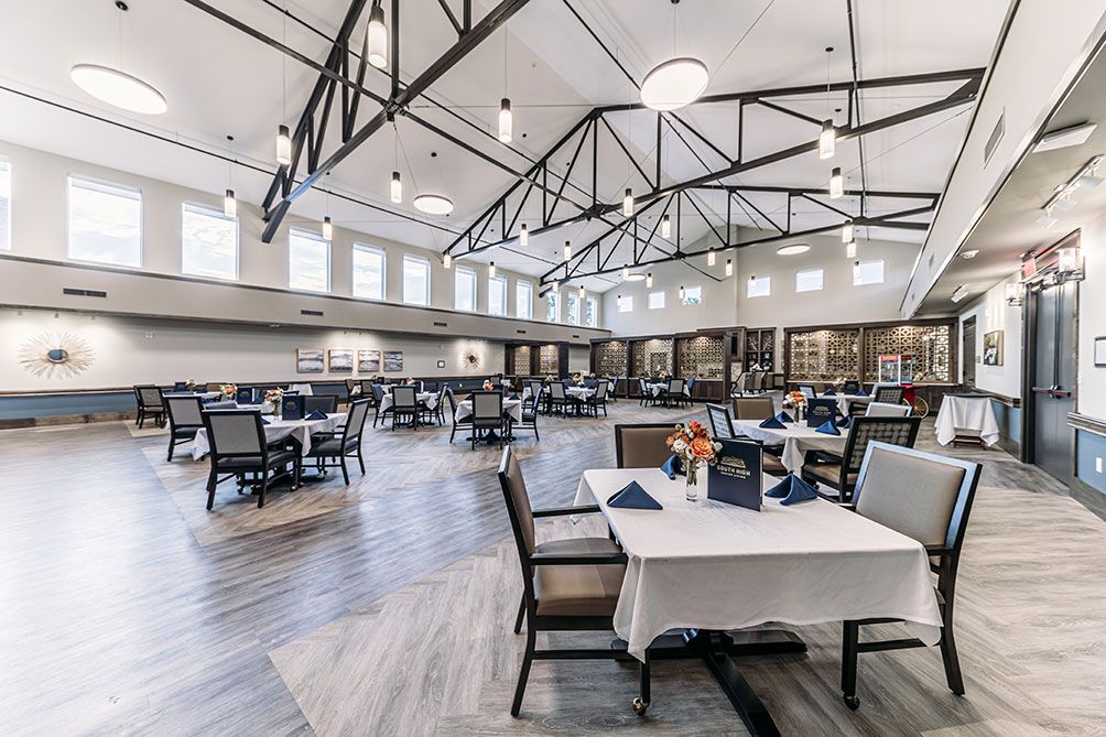 Spacious dining room with elegant table settings and modern decor.