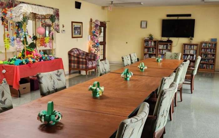A decorated meeting room with a long table, arranged chairs, and festive decorations.