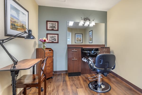 A well-organized hair salon setup with a salon chair, mirror, and wooden furnishings.